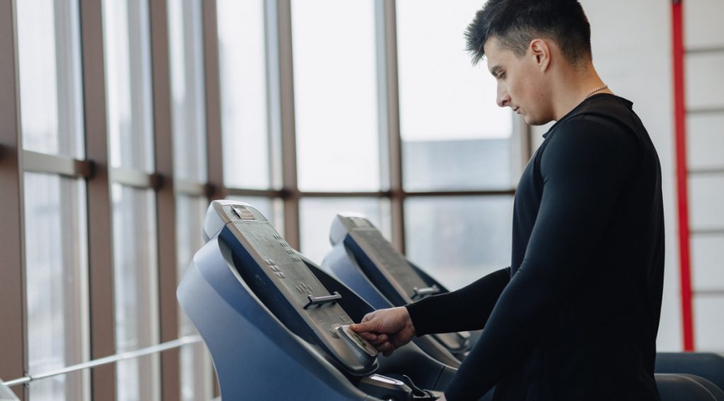 Hombre usando la consola de una cinta de correr